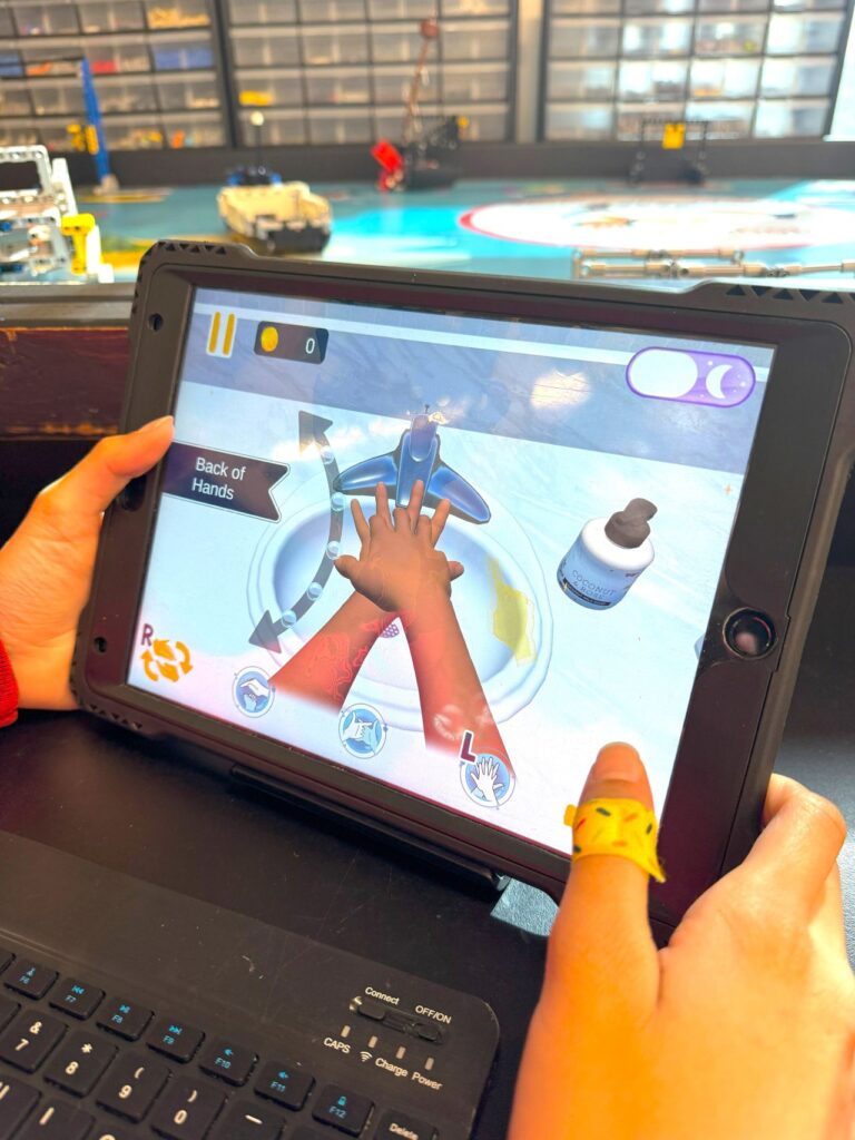 Kid using Bubble Beats hand hygiene trainer developed by Indelible Learning to learn proper handwashing technique.